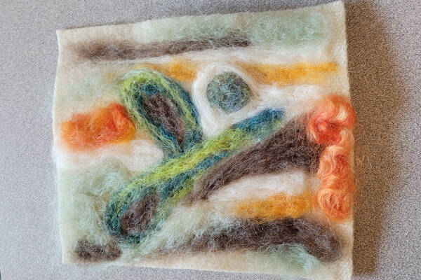 Various colours of wool felted together to make a landscape
