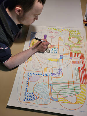 A young man filling in sections of a picture